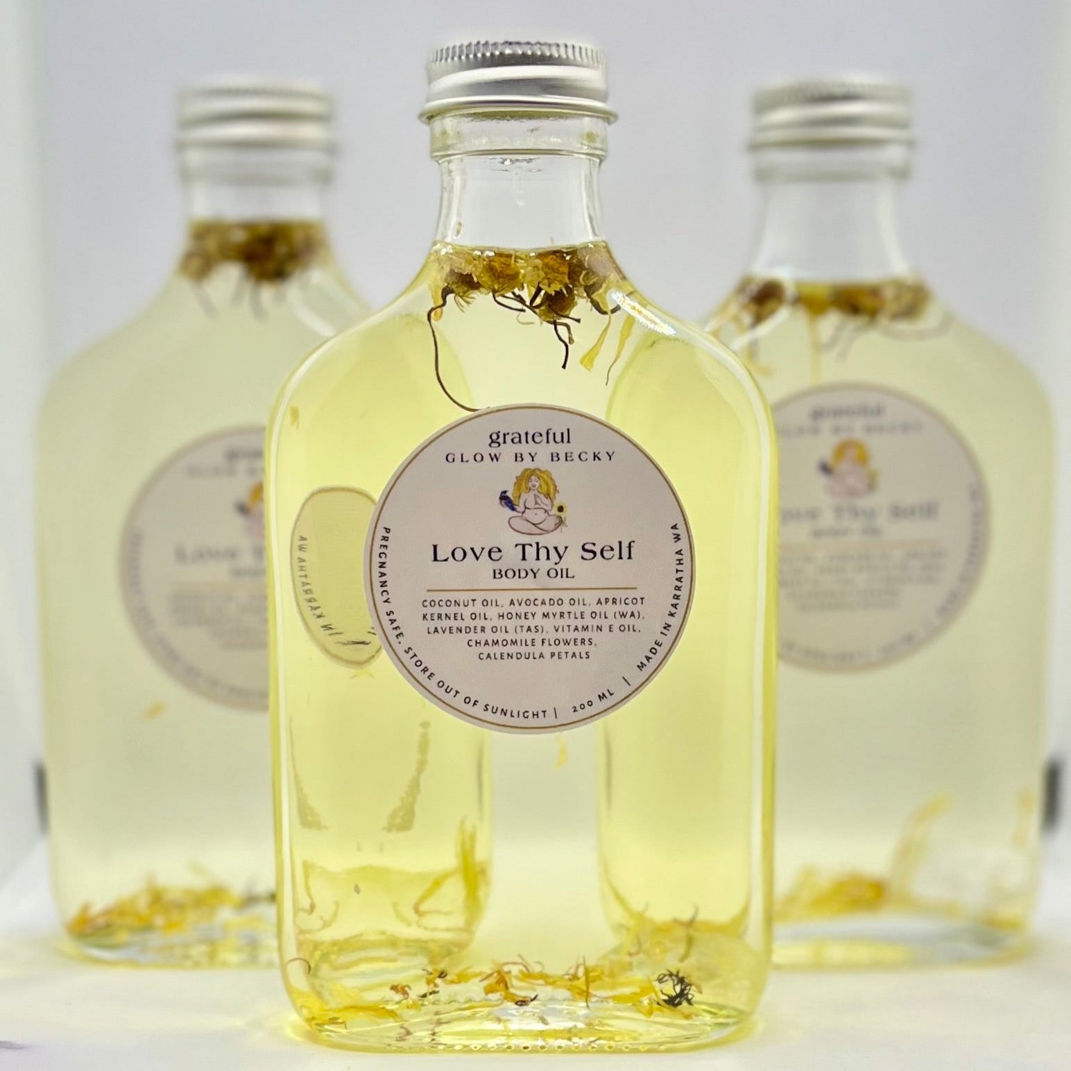 Three bottles of 'Love Thy Self' product with visible labels on a white background