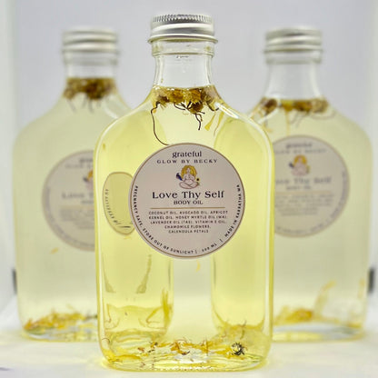 Three bottles of 'Love Thy Self' product with visible labels on a white background