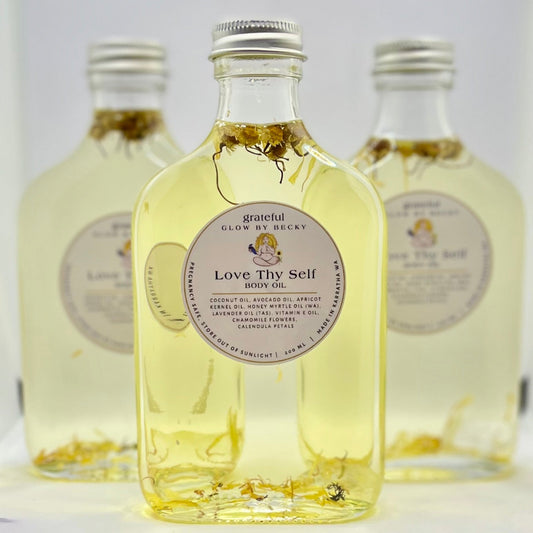 Three bottles of 'Love Thy Self' product with visible labels on a white background