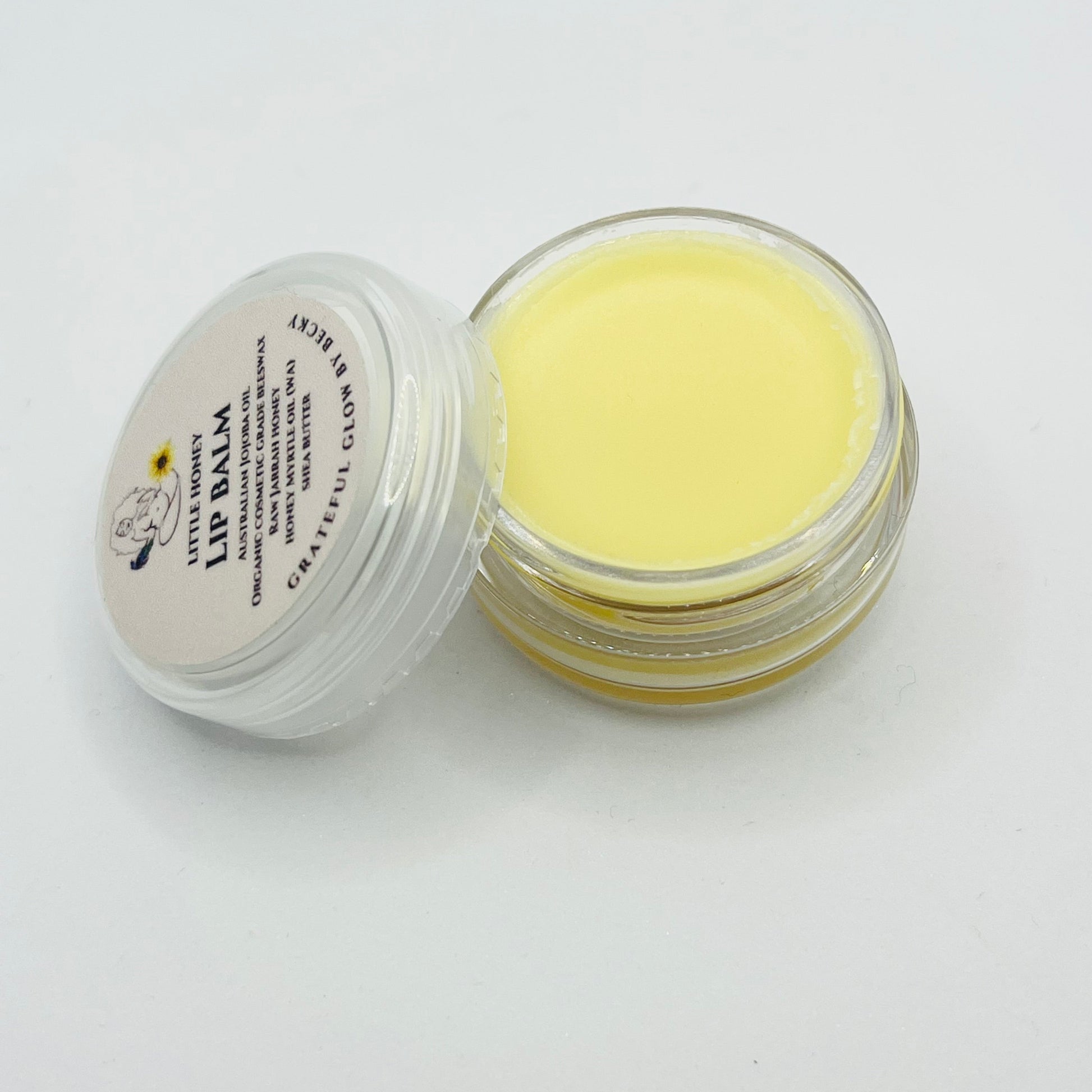Lip balm in a small open container on a white background