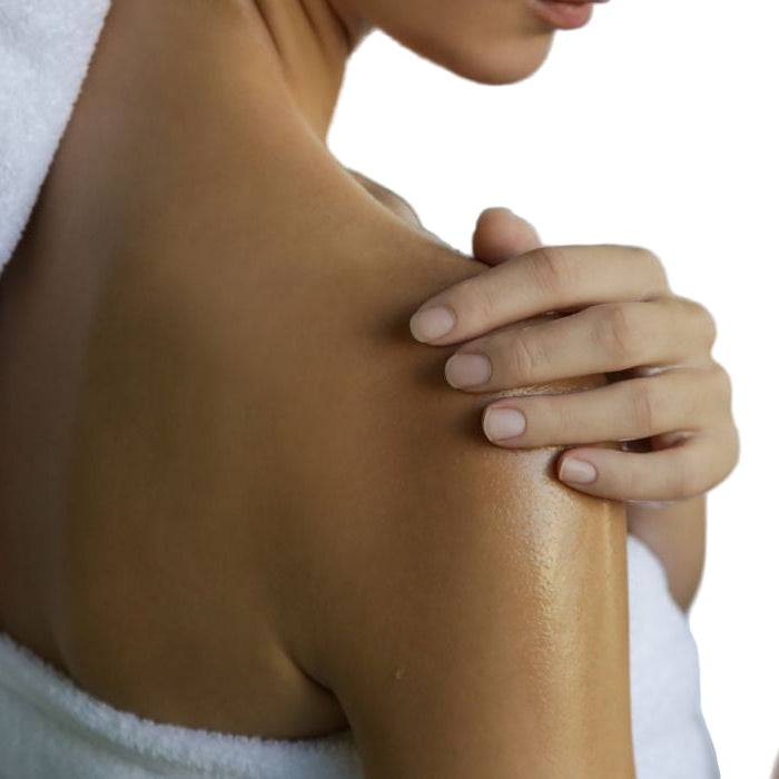 Person with a towel wrapped around their shoulders, touching their arm.